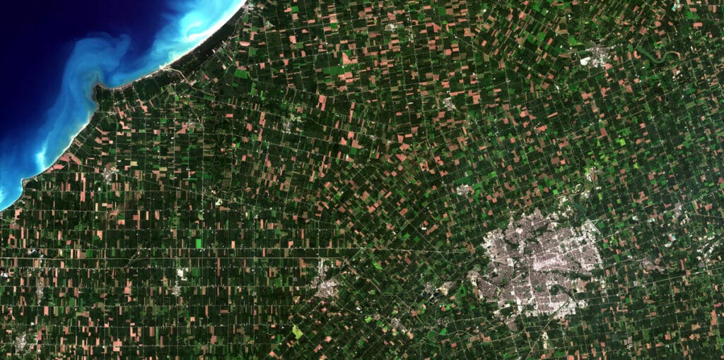 Medium-resolution satellite image of farmland and a coastline, the class of imagery LandViewer subscriptions cover